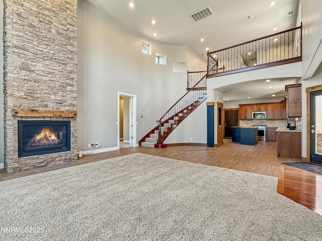 6348 Chilhowee Ct, Sparks, NV 89436 - unfurnished living room featuring light wood finished floors, a high ceiling, recessed lighting, stairway, and a stone fireplace