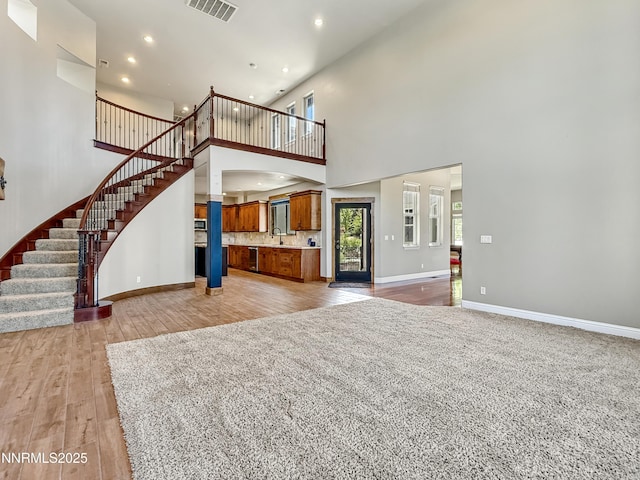6348 Chilhowee Ct, Sparks, NV 89436 - unfurnished living room featuring a towering ceiling, stairway, recessed lighting, and light wood finished floors