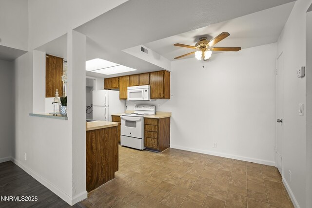 555 E Patriot Blvd Unit 218, Reno, NV 89511 - kitchen with white appliances, light countertops, ceiling fan, a skylight, and brown cabinetry