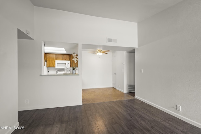555 E Patriot Blvd Unit 218, Reno, NV 89511 - unfurnished living room with dark wood-type flooring, a towering ceiling, and ceiling fan