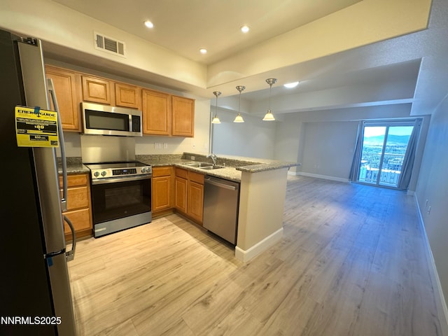 200 W 2nd St Unit 1107, Reno, NV 89501 - kitchen with stainless steel appliances, a peninsula, light wood-type flooring, decorative light fixtures, and light stone countertops