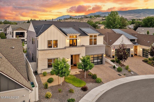 206 Criollo Ct, Reno, NV 89511 - view of front facade featuring board and batten siding, decorative driveway, a mountain view, and a standing seam roof