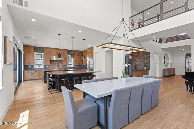 206 Criollo Ct, Reno, NV 89511 - dining room featuring light wood-style flooring, recessed lighting, and a towering ceiling