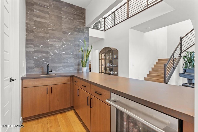 206 Criollo Ct, Reno, NV 89511 - bar with arched walkways, light wood-type flooring, stairway, a towering ceiling, and tasteful backsplash