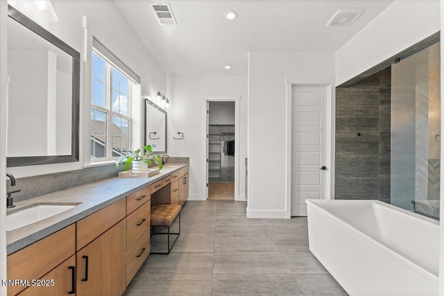 206 Criollo Ct, Reno, NV 89511 - bathroom featuring a freestanding bath, double vanity, a walk in closet, and recessed lighting