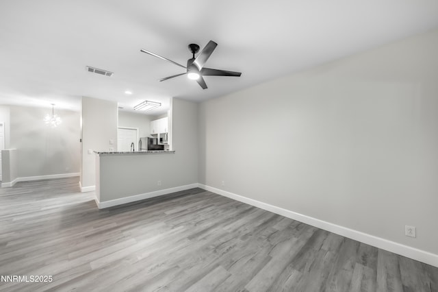 900 S Meadows Pkwy Apt 322, Reno, NV 89521 - unfurnished living room with a chandelier, wood finished floors, and ceiling fan