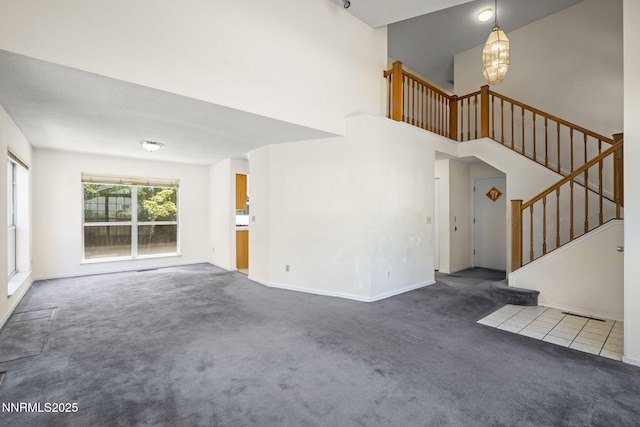 940 Skyway Dr, Reno, NV 89523 - unfurnished living room with carpet flooring, stairway, a chandelier, and a high ceiling