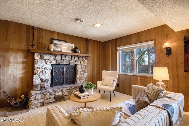 128 Holly Ln Unit B, Stateline, NV 89449 - living room featuring a textured ceiling, wood walls, a stone fireplace, and carpet