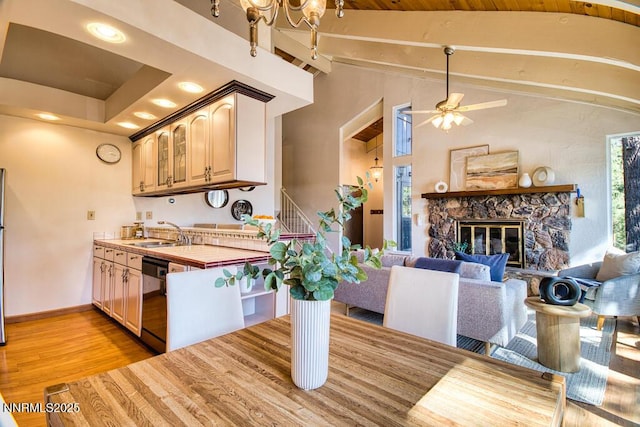 128 Holly Ln Unit B, Stateline, NV 89449 - kitchen featuring dishwashing machine, light wood-style flooring, tile counters, a ceiling fan, and a stone fireplace