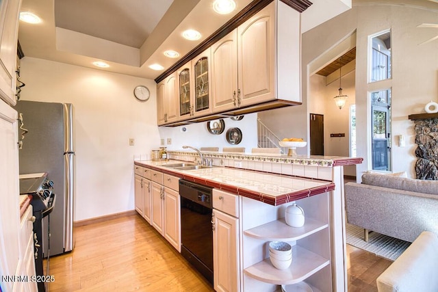 128 Holly Ln Unit B, Stateline, NV 89449 - kitchen with black dishwasher, a peninsula, light wood finished floors, stove, and recessed lighting
