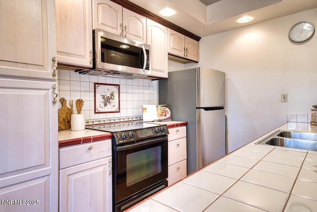 128 Holly Ln Unit B, Stateline, NV 89449 - kitchen with stainless steel appliances, tile counters, decorative backsplash, and recessed lighting