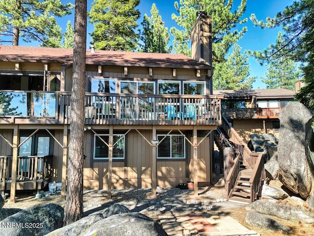 128 Holly Ln Unit B, Stateline, NV 89449 - rear view of property with stairs, a chimney, a deck, and a patio area