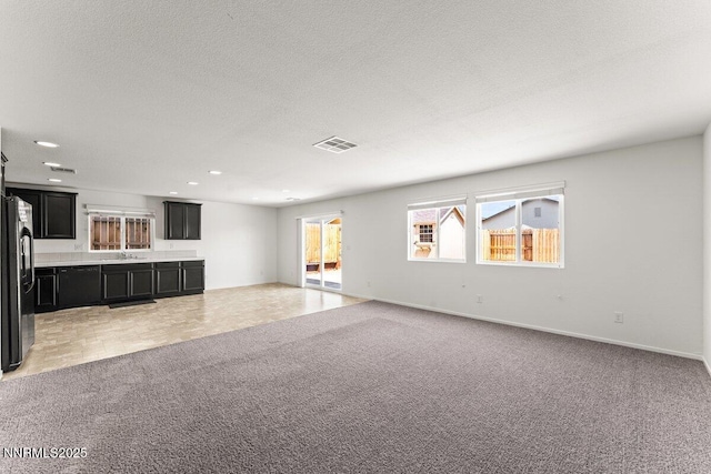 10965 Bloomsburg Dr, Reno, NV 89506 - unfurnished living room featuring light carpet, recessed lighting, and a textured ceiling