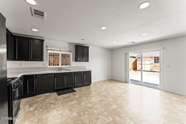 10965 Bloomsburg Dr, Reno, NV 89506 - kitchen with black appliances, dark cabinets, light countertops, a textured ceiling, and recessed lighting