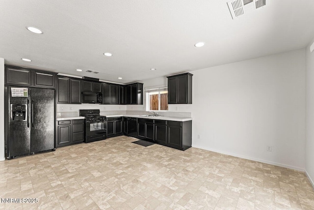 10965 Bloomsburg Dr, Reno, NV 89506 - kitchen featuring black appliances, light countertops, dark cabinetry, recessed lighting, and stone finish floors