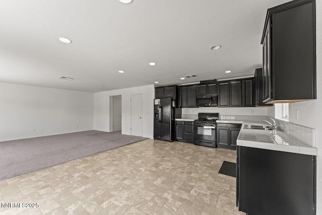 10965 Bloomsburg Dr, Reno, NV 89506 - kitchen with black appliances, tile countertops, dark cabinets, recessed lighting, and open floor plan