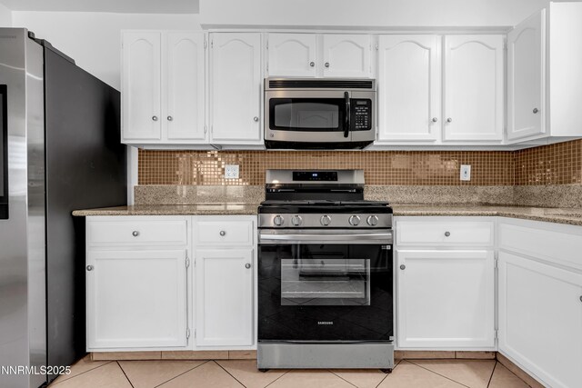 185 Marmot Dr, Reno, NV 89523 - kitchen featuring stainless steel appliances, light tile patterned floors, white cabinetry, and tasteful backsplash