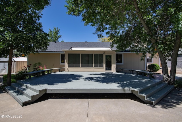 185 Marmot Dr, Reno, NV 89523 - rear view of property featuring a sunroom, a deck, a storage unit, and a shingled roof