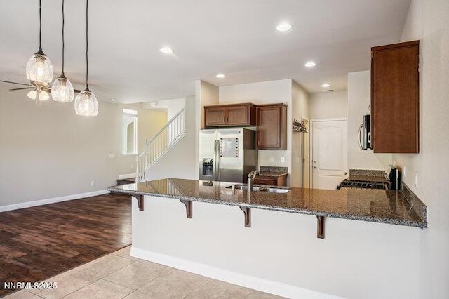 1825 Star Bright Way, Reno, NV 89523 - kitchen with stainless steel appliances, dark stone countertops, a breakfast bar area, a peninsula, and recessed lighting