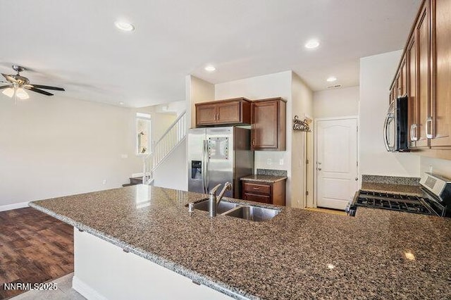 1825 Star Bright Way, Reno, NV 89523 - kitchen featuring stainless steel appliances, dark stone counters, a peninsula, a ceiling fan, and brown cabinetry