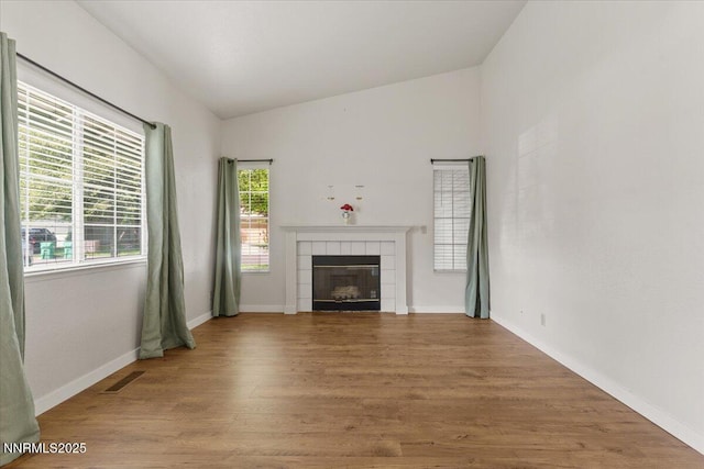 7560 Lighthouse Ln, Reno, NV 89511 - unfurnished living room with vaulted ceiling, wood finished floors, and a tile fireplace