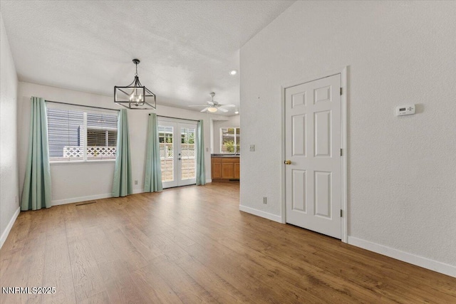 7560 Lighthouse Ln, Reno, NV 89511 - spare room with wood finished floors, french doors, a chandelier, and a textured ceiling