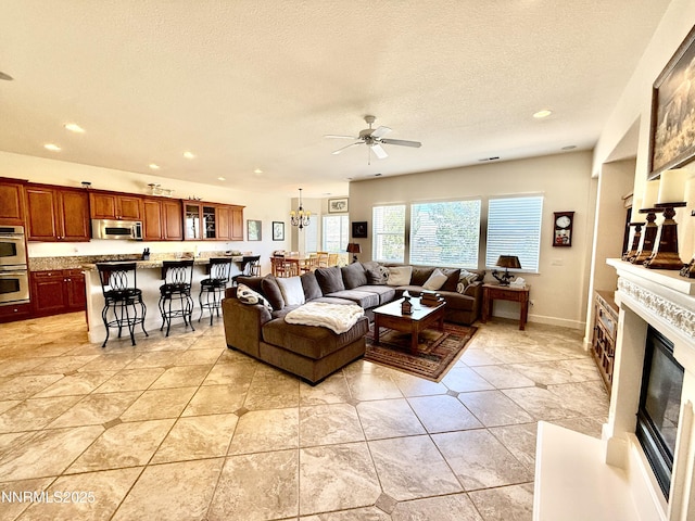 15180 Redmond Lp, Reno, NV 89511 - living area featuring a ceiling fan, recessed lighting, a glass covered fireplace, a textured ceiling, and light tile patterned floors