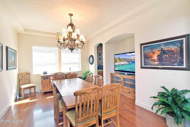 15180 Redmond Lp, Reno, NV 89511 - dining area featuring arched walkways, a chandelier, and wood finished floors