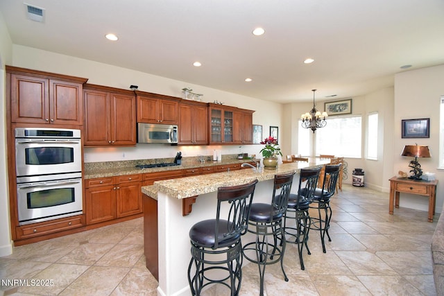 15180 Redmond Lp, Reno, NV 89511 - kitchen featuring appliances with stainless steel finishes, a chandelier, recessed lighting, brown cabinetry, and a breakfast bar