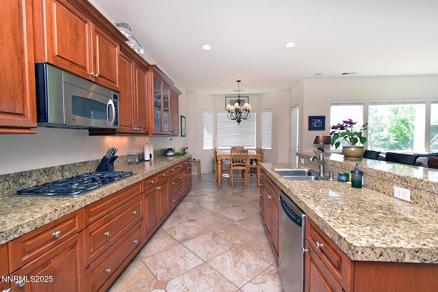15180 Redmond Lp, Reno, NV 89511 - kitchen with stainless steel appliances, a chandelier, glass insert cabinets, brown cabinets, and decorative light fixtures