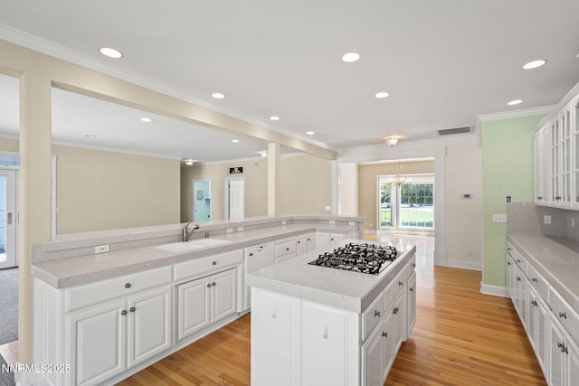 224 Foothill Meadows Ct, Genoa, NV 89411 - kitchen with gas stovetop, dishwasher, a kitchen island, light wood-style flooring, and white cabinets