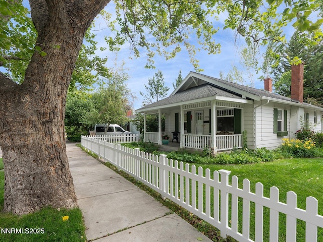 1016 Nixon Ave, Reno, NV 89509 - view of front of home with covered porch, a chimney, a fenced front yard, and a shingled roof