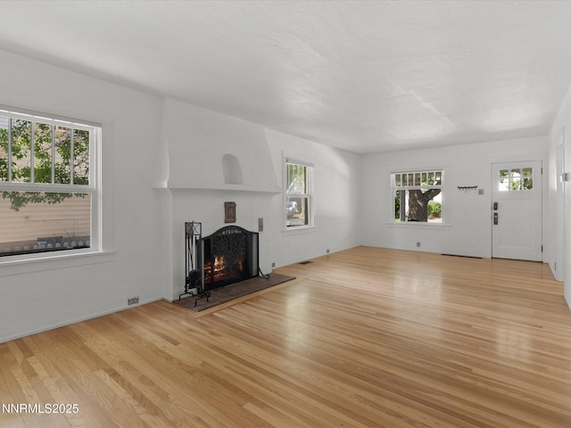 1016 Nixon Ave, Reno, NV 89509 - unfurnished living room with a warm lit fireplace, healthy amount of natural light, and light wood-type flooring