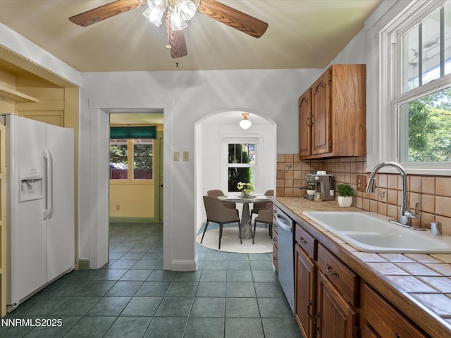1016 Nixon Ave, Reno, NV 89509 - kitchen with tile countertops, white refrigerator with ice dispenser, backsplash, and ceiling fan