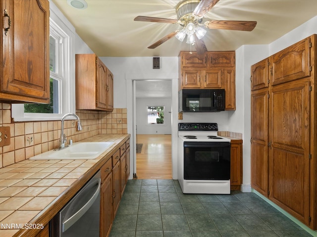 1016 Nixon Ave, Reno, NV 89509 - kitchen with white range with electric cooktop, tile countertops, black microwave, dishwasher, and backsplash