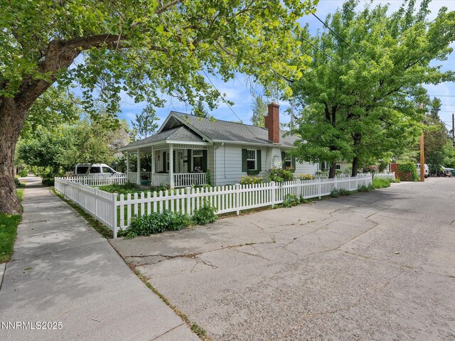 1016 Nixon Ave, Reno, NV 89509 - view of front of home with a chimney, a fenced front yard, roof with shingles, and a porch