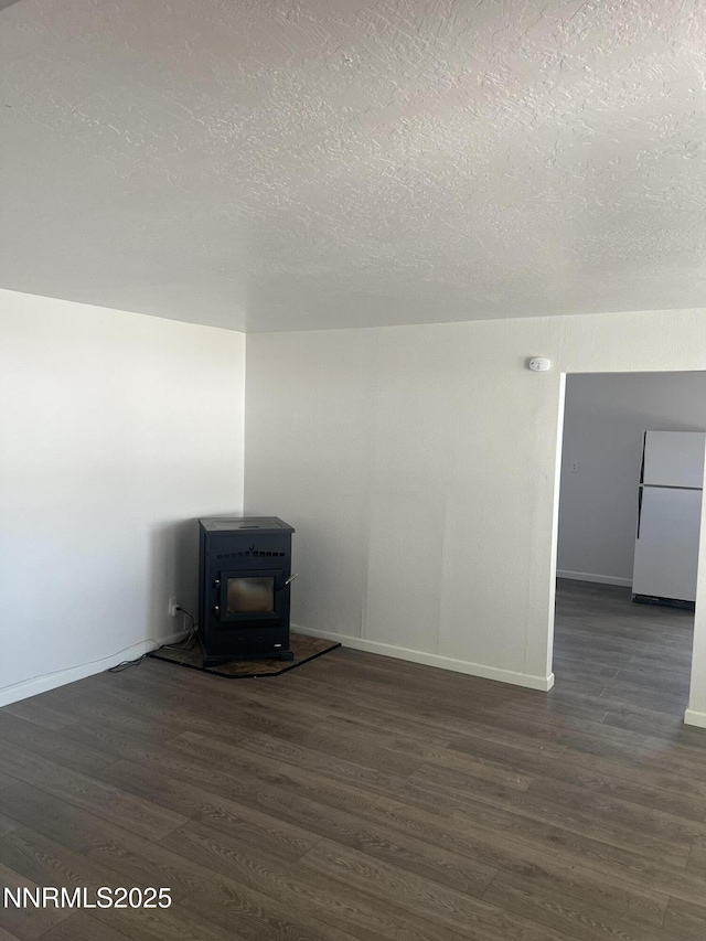 1470 Franklin Ave, Lovelock, NV 89419 - unfurnished living room with a textured ceiling, dark wood-style floors, and a wood stove