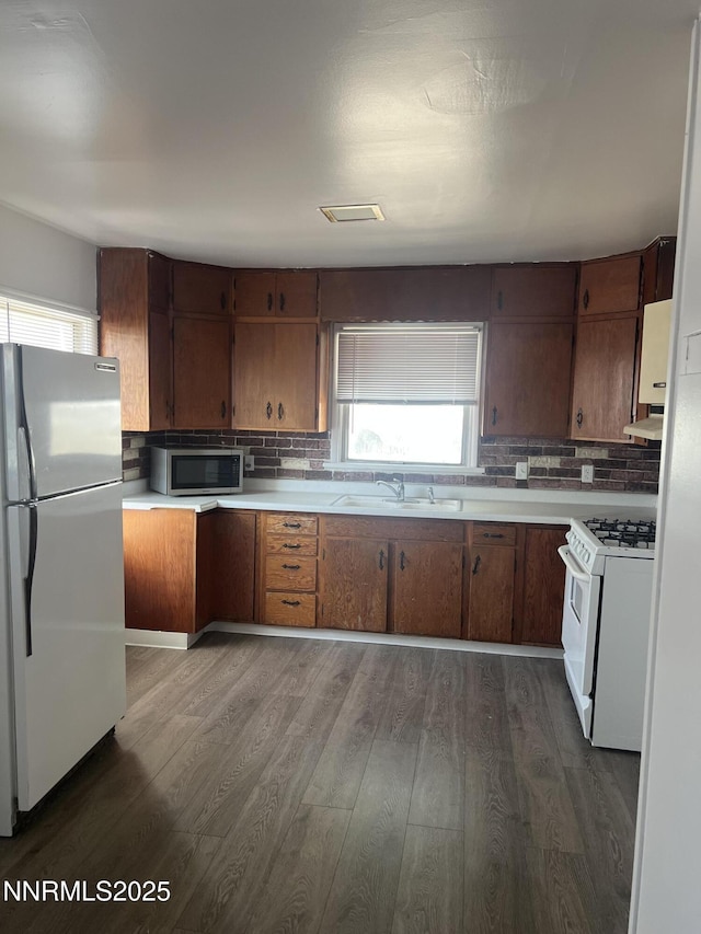 1470 Franklin Ave, Lovelock, NV 89419 - kitchen featuring white appliances, dark wood-style flooring, decorative backsplash, and light countertops