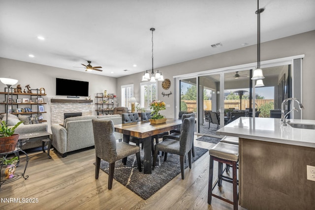 2109 Cast Iron Dr, Reno, NV 89521 - dining space featuring a ceiling fan, light wood finished floors, a fireplace, and recessed lighting