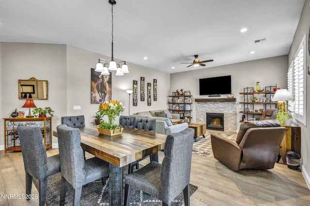 2109 Cast Iron Dr, Reno, NV 89521 - dining space featuring a fireplace, light wood-type flooring, ceiling fan, recessed lighting, and a chandelier