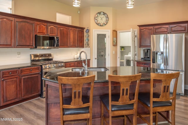 2605 Lerma Ct, Sparks, NV 89436 - kitchen with stainless steel appliances, wood finished floors, and reddish brown cabinets