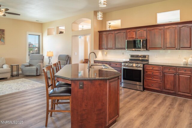 2605 Lerma Ct, Sparks, NV 89436 - kitchen featuring appliances with stainless steel finishes, a breakfast bar area, and light wood finished floors