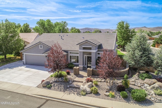 2605 Lerma Ct, Sparks, NV 89436 - view of front of house with a mountain view, a garage, driveway, and stucco siding