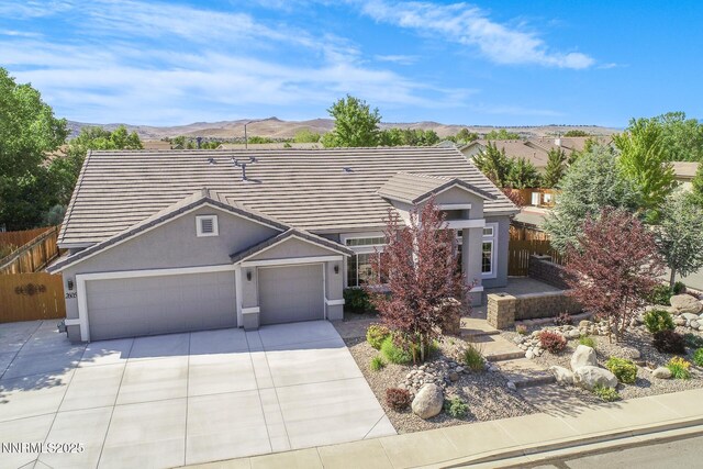 2605 Lerma Ct, Sparks, NV 89436 - view of front of home featuring a garage, driveway, a mountain view, stucco siding, and a tiled roof