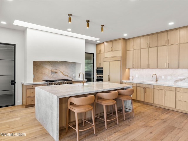 3662 Spirit Bluff Ct, Reno, NV 89511 - kitchen with light brown cabinetry, decorative backsplash, light stone countertops, recessed lighting, and light wood-style floors