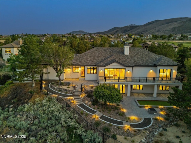 3662 Spirit Bluff Ct, Reno, NV 89511 - rear view of house featuring a fire pit, stucco siding, a mountain view, stairs, and a patio area