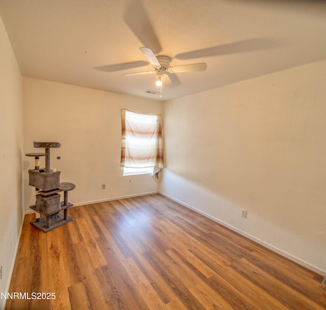 9698 Canyon Meadows Dr, Reno, NV 89506 - unfurnished room with a wood stove, a ceiling fan, and wood finished floors