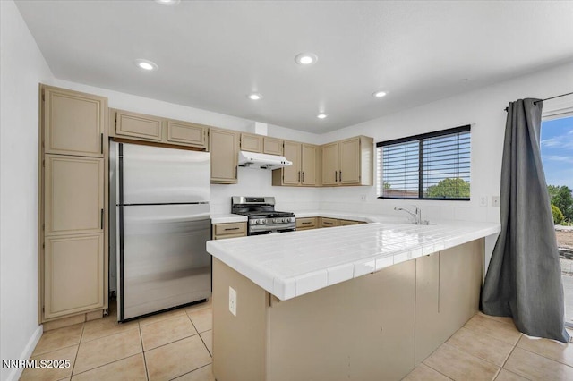 1592 Reno View Dr, Reno, NV 89523 - kitchen featuring appliances with stainless steel finishes, under cabinet range hood, healthy amount of natural light, a peninsula, and recessed lighting