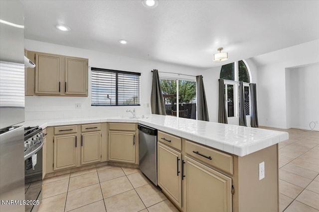 1592 Reno View Dr, Reno, NV 89523 - kitchen featuring stainless steel appliances, a peninsula, light tile patterned floors, recessed lighting, and tile countertops