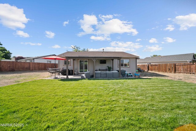 6340 E Choctaw Ct, Sun Valley, NV 89433 - back of property with an outdoor hangout area, a fenced backyard, a patio, and stucco siding